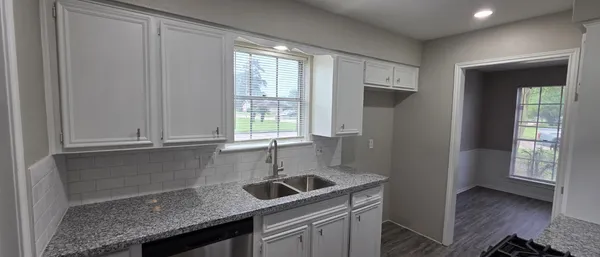 a kitchen with stainless steel appliances granite countertop a sink a stove and a refrigerator