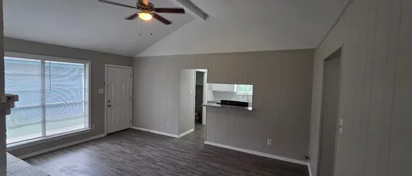 a view of a livingroom with wooden floor and a ceiling fan