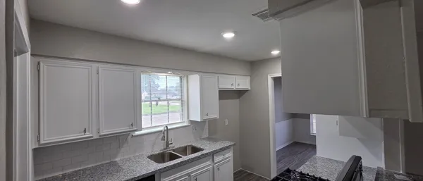 a kitchen with stainless steel appliances granite countertop a refrigerator and a sink