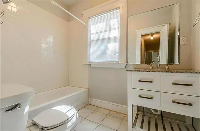 a bathroom with a sink a toilet a mirror and bathtub