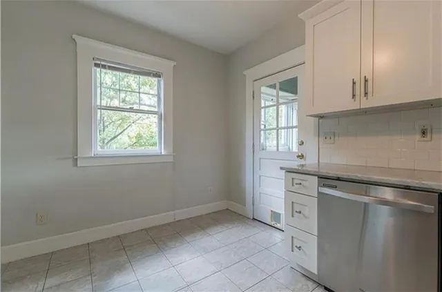 a kitchen with granite countertop white cabinets and white appliances