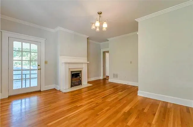 a view of an empty room with window and wooden floor