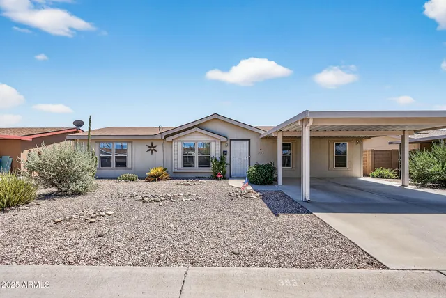 a view of a house with a patio and a yard