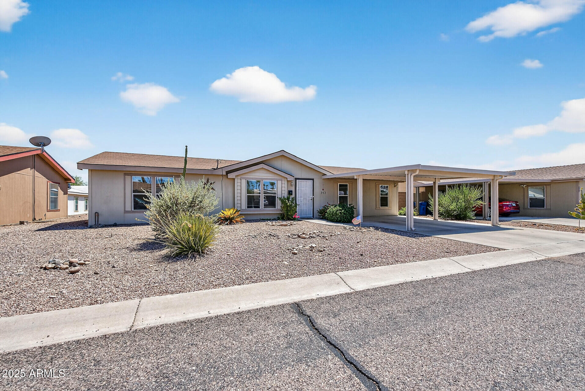16101 North El Mirage Road, Unit 353 El Mirage, AZ 85335 - Photo 2 of 46 a front view of white house with a yard and potted plants