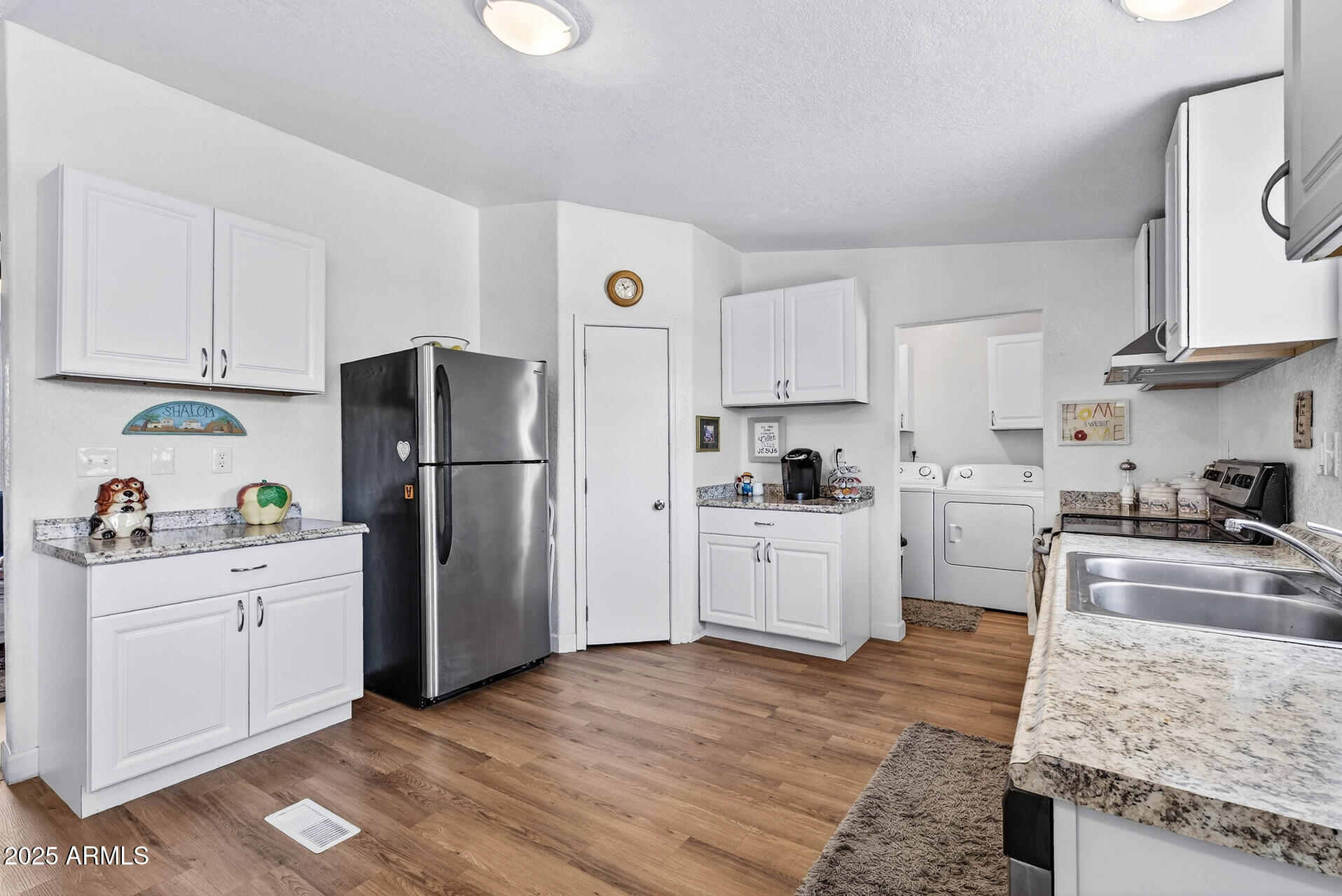16101 North El Mirage Road, Unit 353 El Mirage, AZ 85335 - Photo 9 of 46 a kitchen with a refrigerator a stove top oven a sink and cabinets