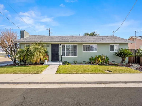 a front view of a house with garden and parking