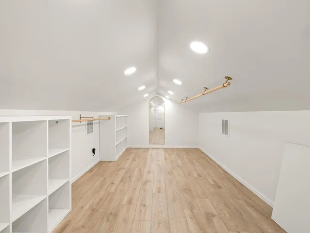 a view of empty room with wooden floor and windows