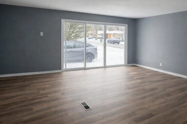 wooden floor in an empty room with a window