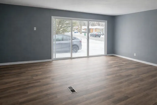 wooden floor in an empty room with a window