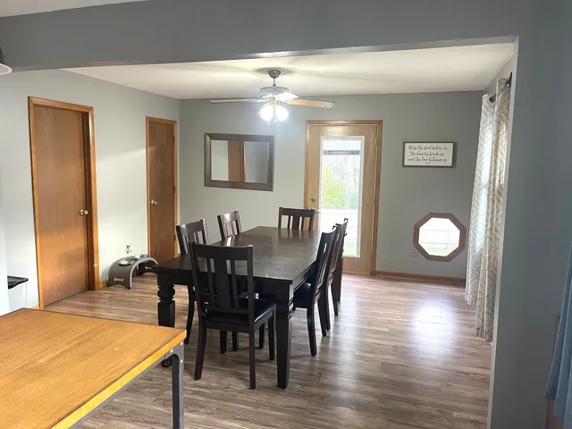 a kitchen with granite countertop a stove a sink a dining table and chairs