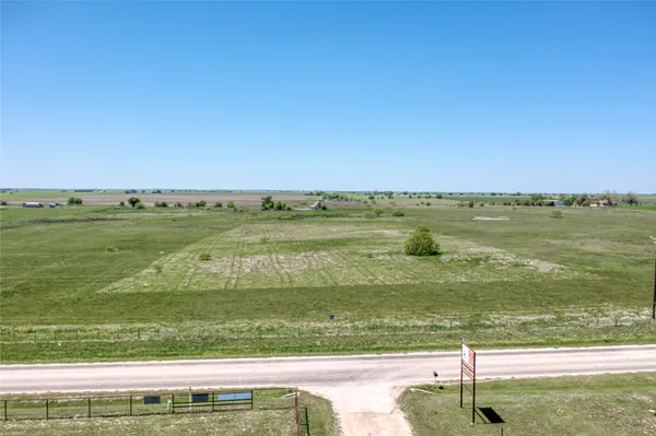a view of a field with an ocean view
