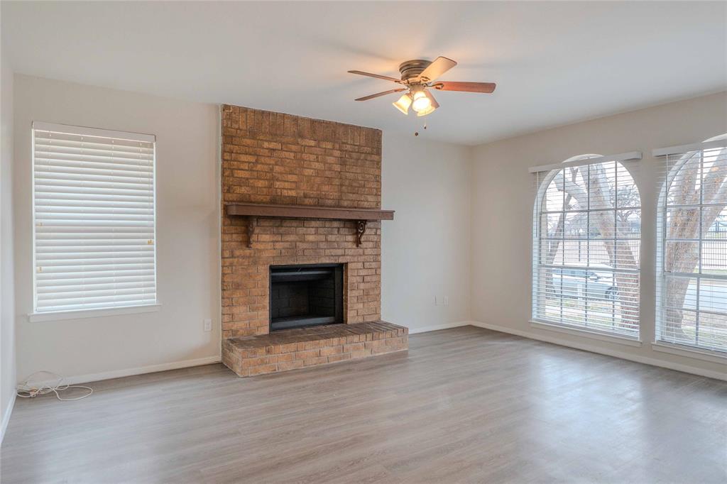 527 Crowley Road Arlington, TX 76012 - Photo 8 of 20 Unfurnished living room with light wood-type flooring, ceiling fan, and a brick fireplace