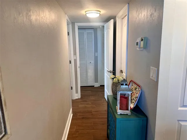 a view of a hallway with wooden floor and closet