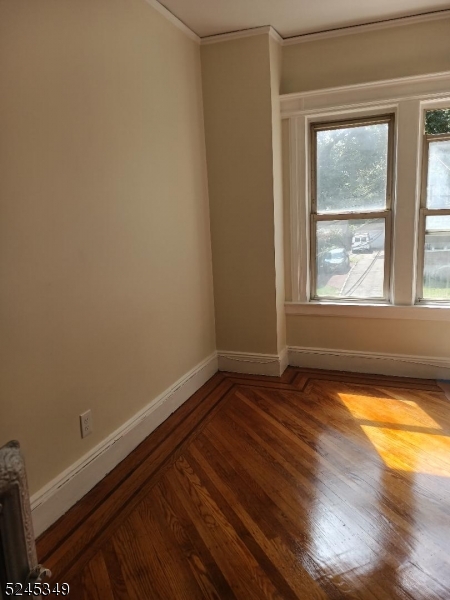 57 Maolis Avenue, Unit 2 Bloomfield, NJ 07003 - Photo 2 of 11 an empty room with wooden floor and windows