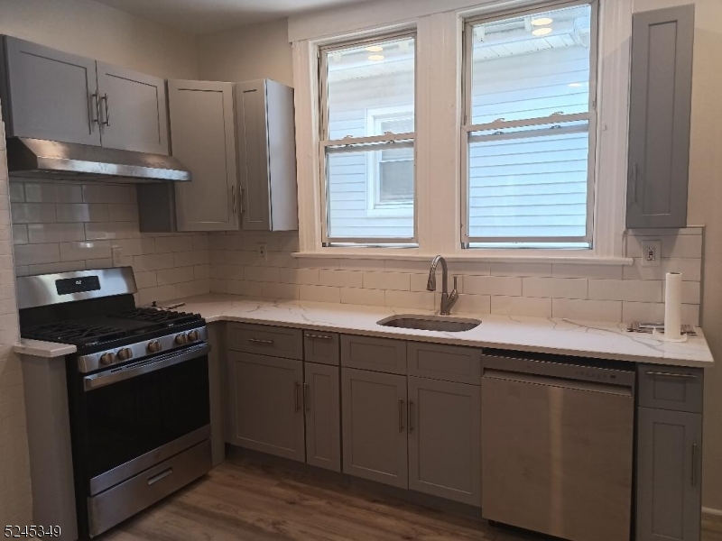 57 Maolis Avenue, Unit 2 Bloomfield, NJ 07003 - Photo 4 of 11 a kitchen with granite countertop a sink cabinets stainless steel appliances and a window