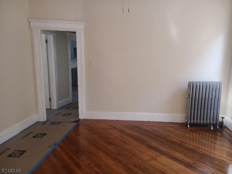 57 Maolis Avenue, Unit 2 Bloomfield, NJ 07003 - Photo 7 of 11 an empty room with wooden floor and windows