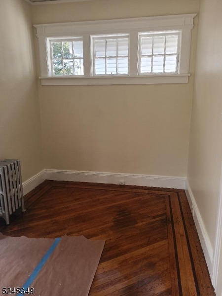 57 Maolis Avenue, Unit 2 Bloomfield, NJ 07003 - Photo 8 of 11 an empty room with wooden floor and windows