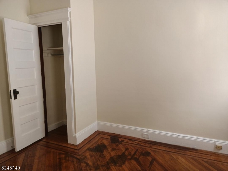 57 Maolis Avenue, Unit 2 Bloomfield, NJ 07003 - Photo 9 of 11 an empty room with wooden floor and closet