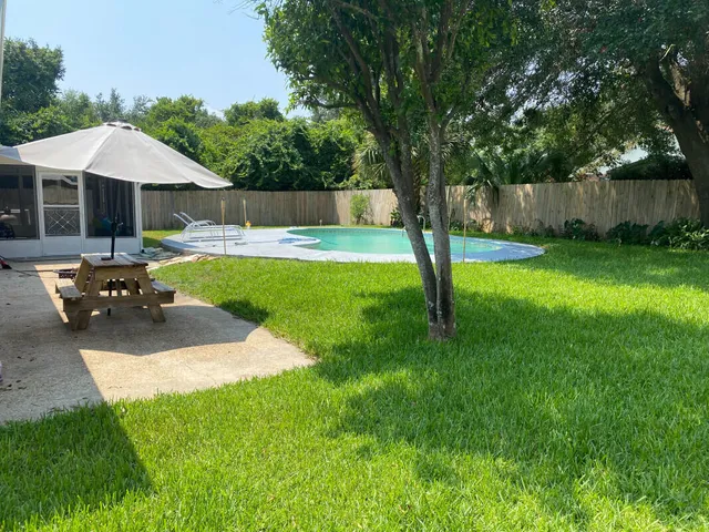 a swimming pool with outdoor seating and garden
