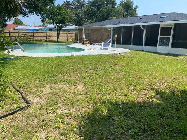 a view of house with swimming pool and a table and chairs