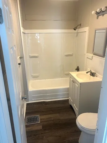 a bathroom with a sink a toilet a mirror and shower