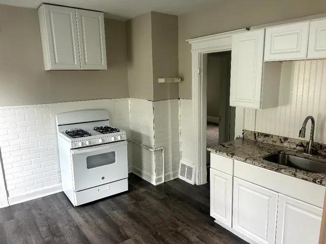 a kitchen with a sink stove and cabinets