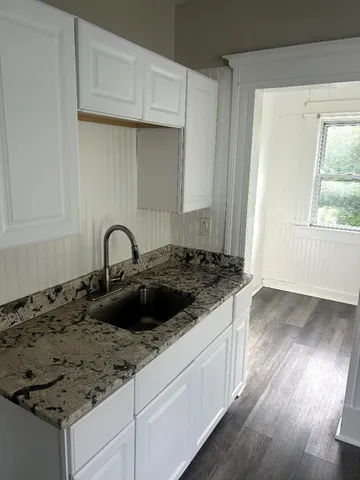 a kitchen with granite countertop a sink and a stove top oven