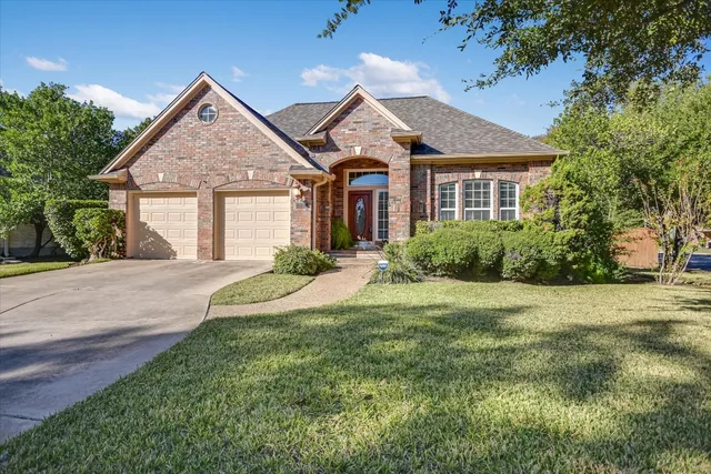 a front view of a house with a yard and potted plants