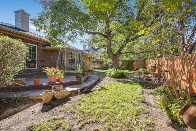 a view of a brick house with a yard and potted plants