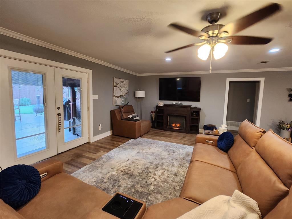 1023 Ridgefield Drive Plano, TX 75075 - Photo 8 of 39 a living room with furniture a flat screen tv and a fireplace