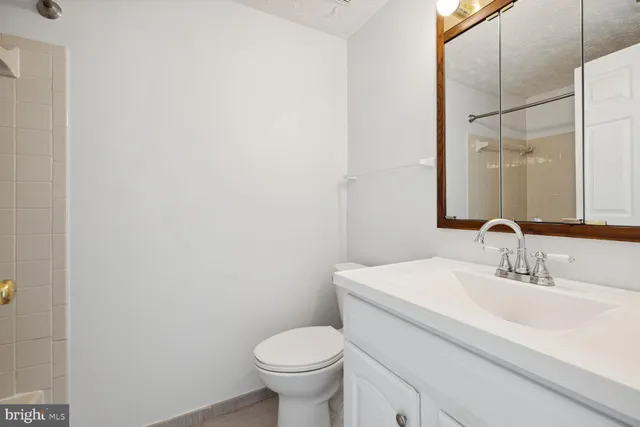 a bathroom with a sink toilet and a mirror