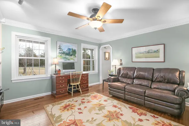 a dining room with furniture a chandelier and wooden floor