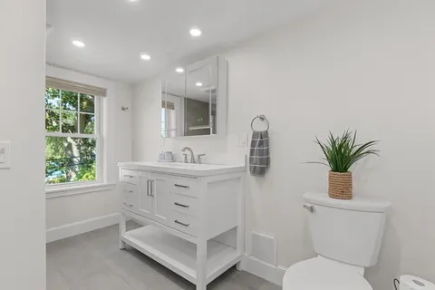 a bathroom with a sink a toilet and shower