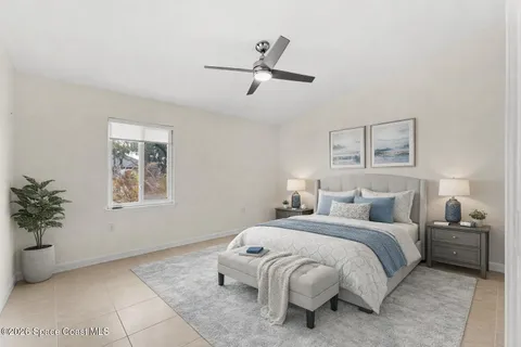 a bedroom with a bed and a potted plant