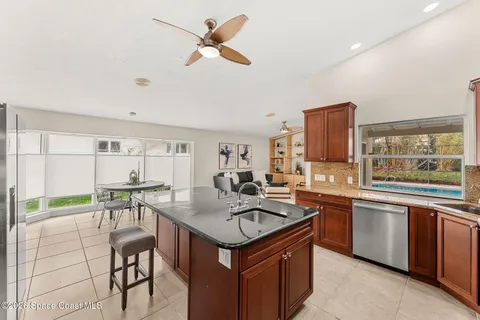 a kitchen with a stove a sink dishwasher and a refrigerator with wooden floor