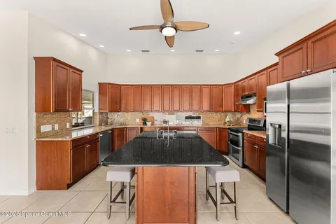 a kitchen with stainless steel appliances granite countertop a refrigerator a sink and a stove
