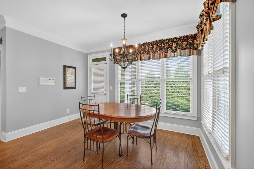 3315 Kylee Dawn Circle Lawrenceville, GA 30045 - Photo 19 of 97 a dining room with furniture a chandelier and wooden floor