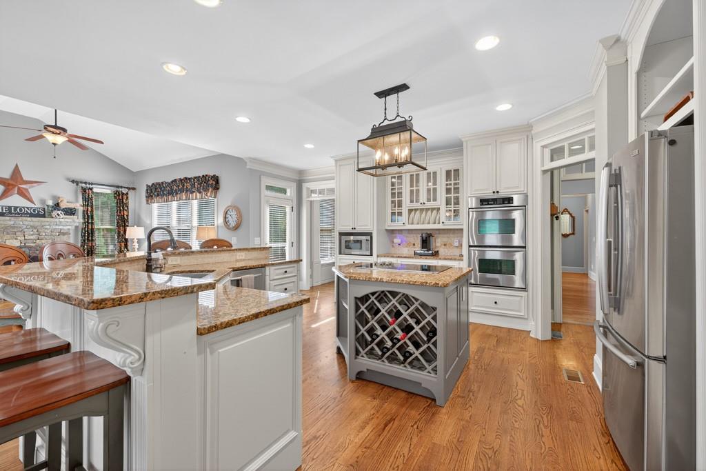 3315 Kylee Dawn Circle Lawrenceville, GA 30045 - Photo 20 of 97 a kitchen with stainless steel appliances kitchen island granite countertop a refrigerator and a stove top oven