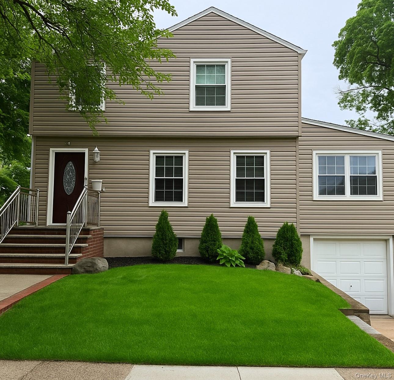 Colonial house with a front yard and a garage