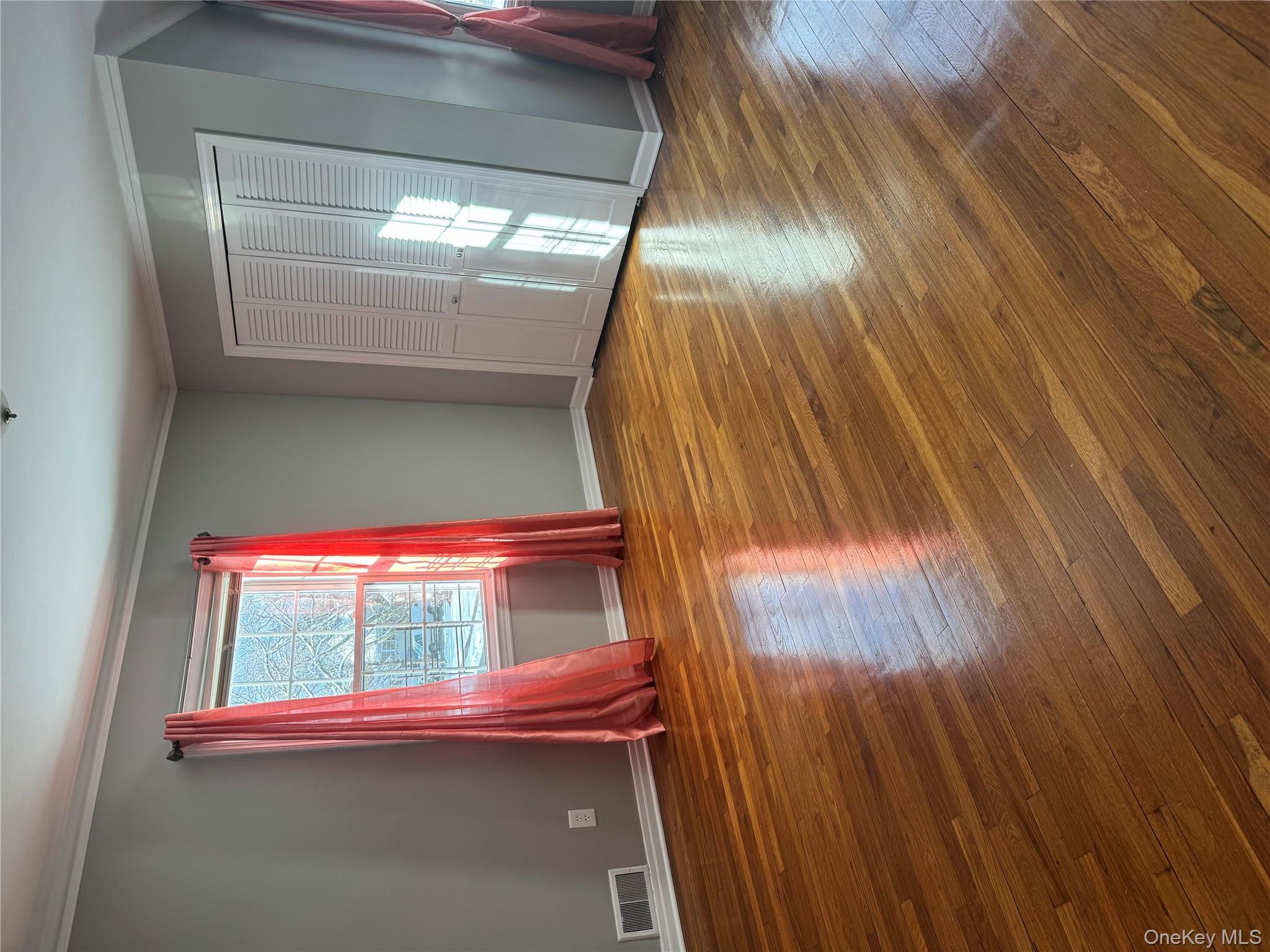 31 Flower Road Valley Stream, NY 11581 - Photo 12 of 16 Unfurnished bedroom with ornamental molding, wood-type flooring, and a closet