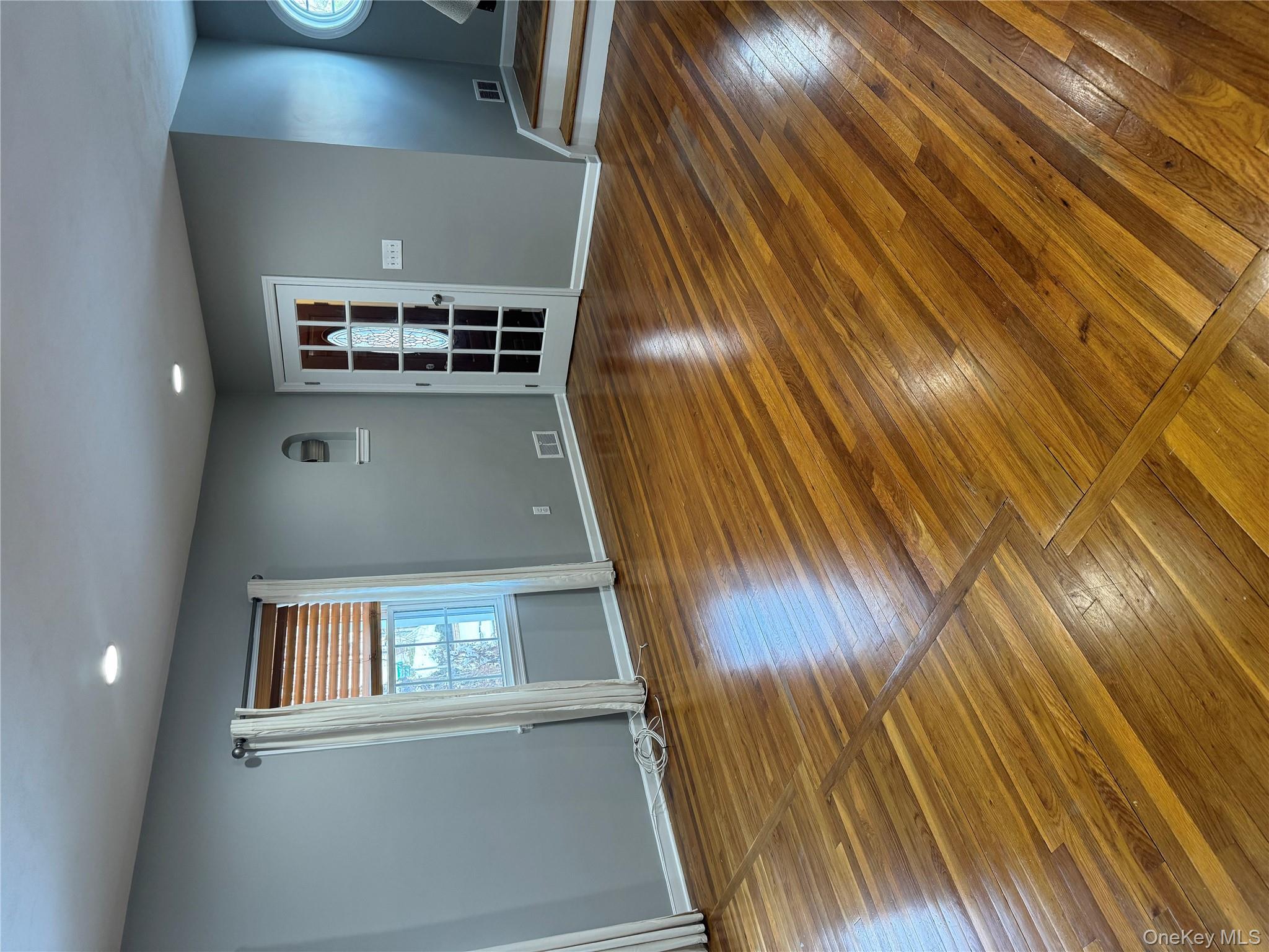 31 Flower Road Valley Stream, NY 11581 - Photo 2 of 16 Spare room with wood-type flooring, recessed lighting, and stairs