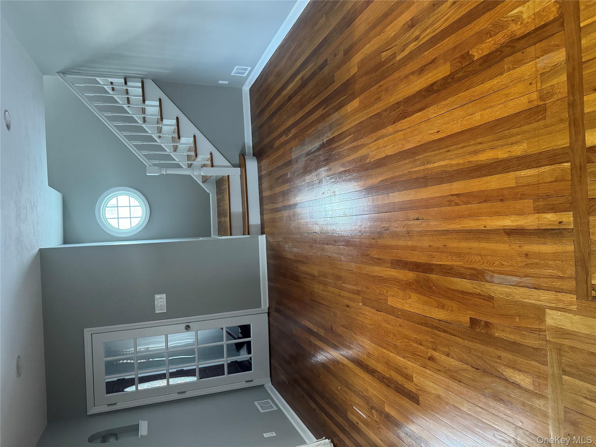 31 Flower Road Valley Stream, NY 11581 - Photo 3 of 16 Unfurnished living room featuring stairs and dark wood-type flooring