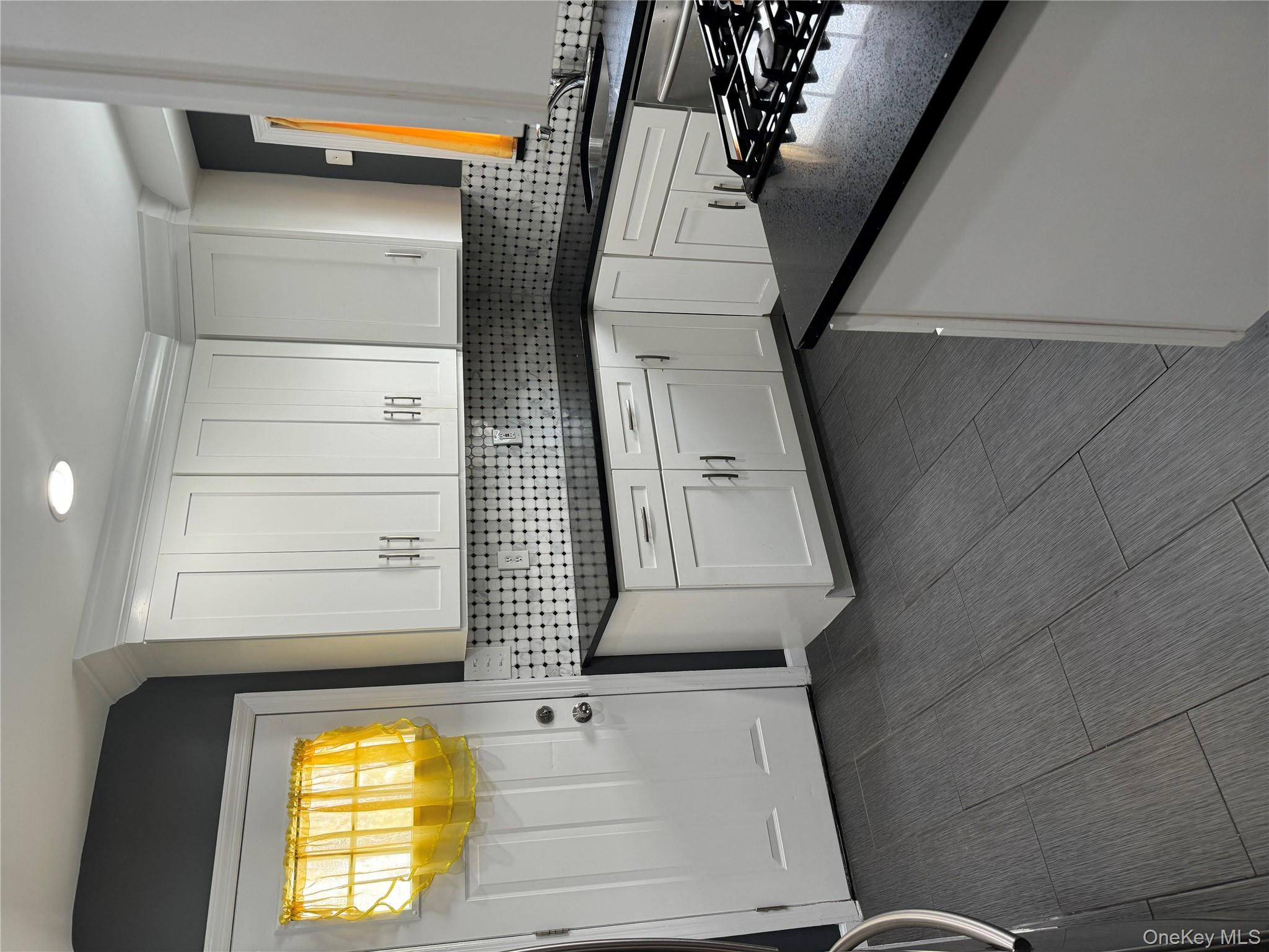 31 Flower Road Valley Stream, NY 11581 - Photo 6 of 16 Kitchen with white cabinetry, dark stone counters, and backsplash