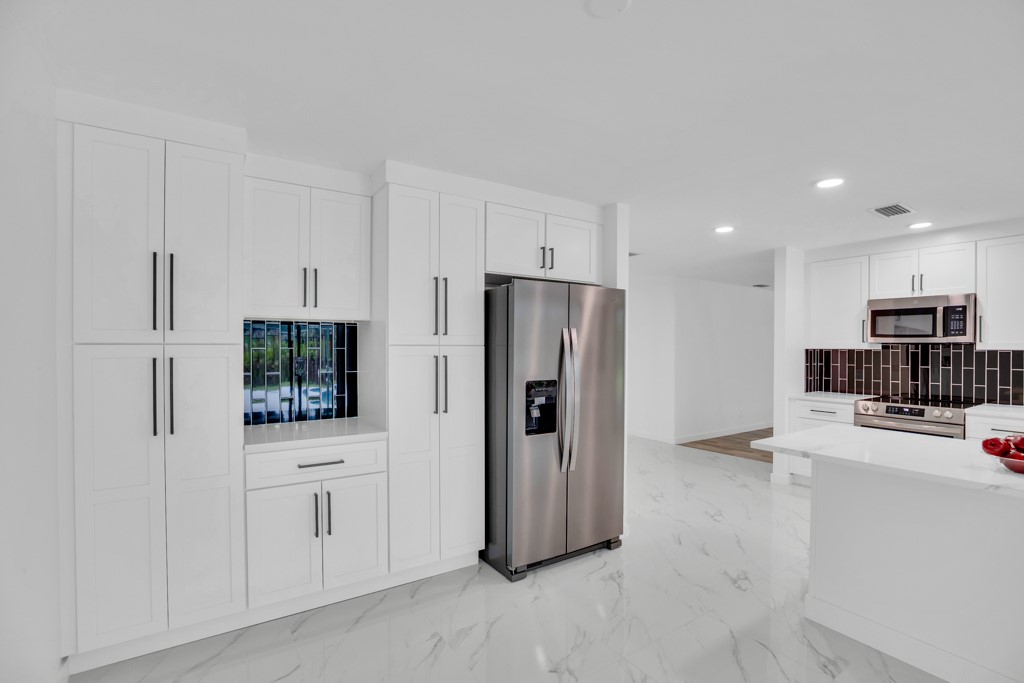 4384 2nd Square Southwest Vero Beach, FL 32968 - Photo 13 of 36 a kitchen with stainless steel appliances a refrigerator and a stove top oven