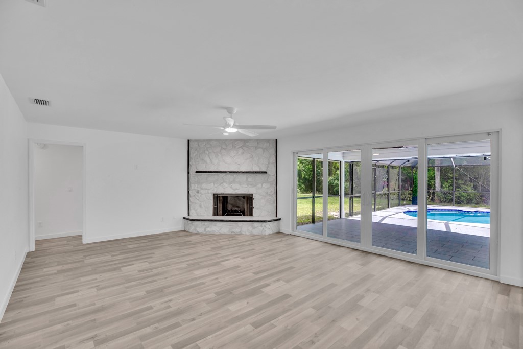 4384 2nd Square Southwest Vero Beach, FL 32968 - Photo 16 of 36 a view of an empty room with wooden floor and a fireplace