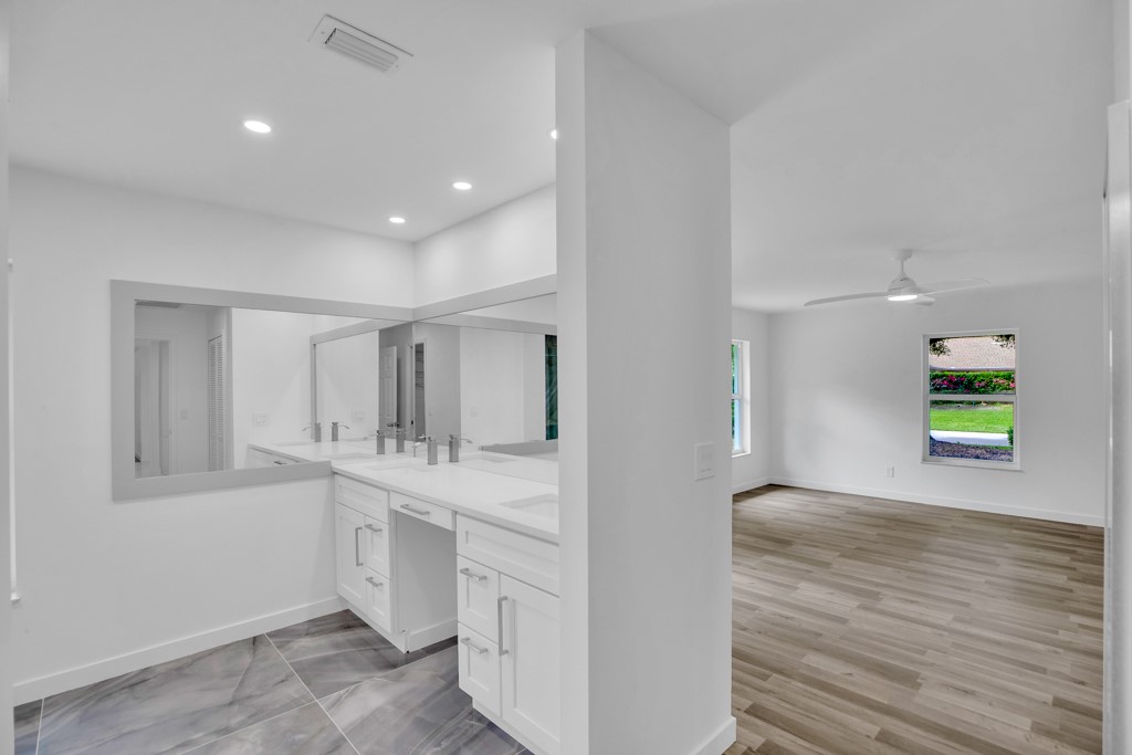 4384 2nd Square Southwest Vero Beach, FL 32968 - Photo 19 of 36 a spacious bathroom with a double vanity sink and a mirror