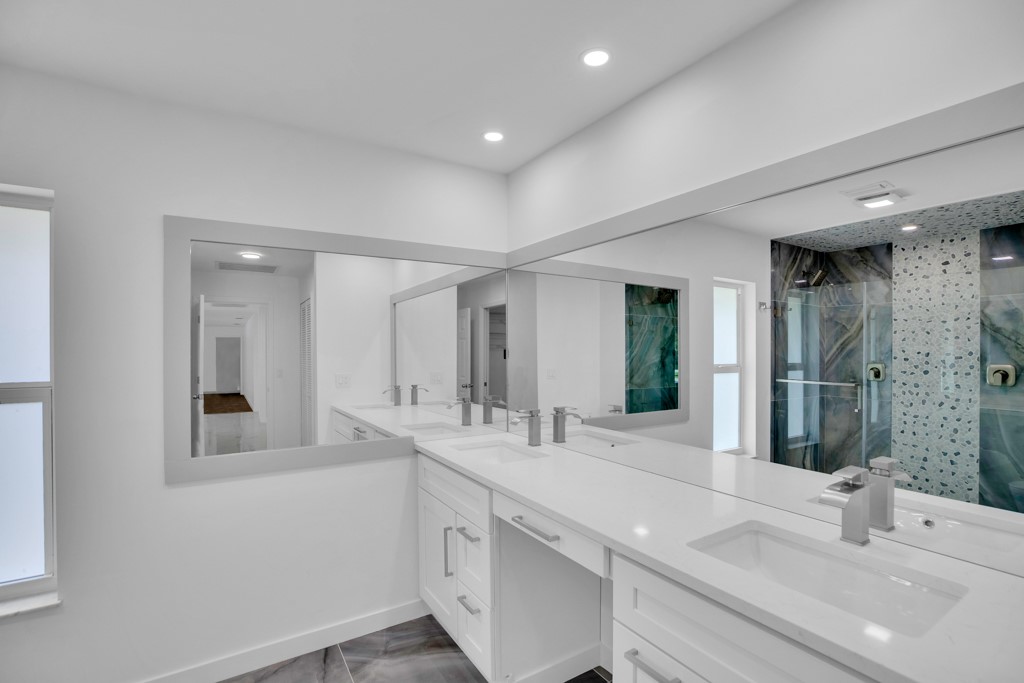 4384 2nd Square Southwest Vero Beach, FL 32968 - Photo 28 of 36 a bathroom with double vanity sinks and a mirror
