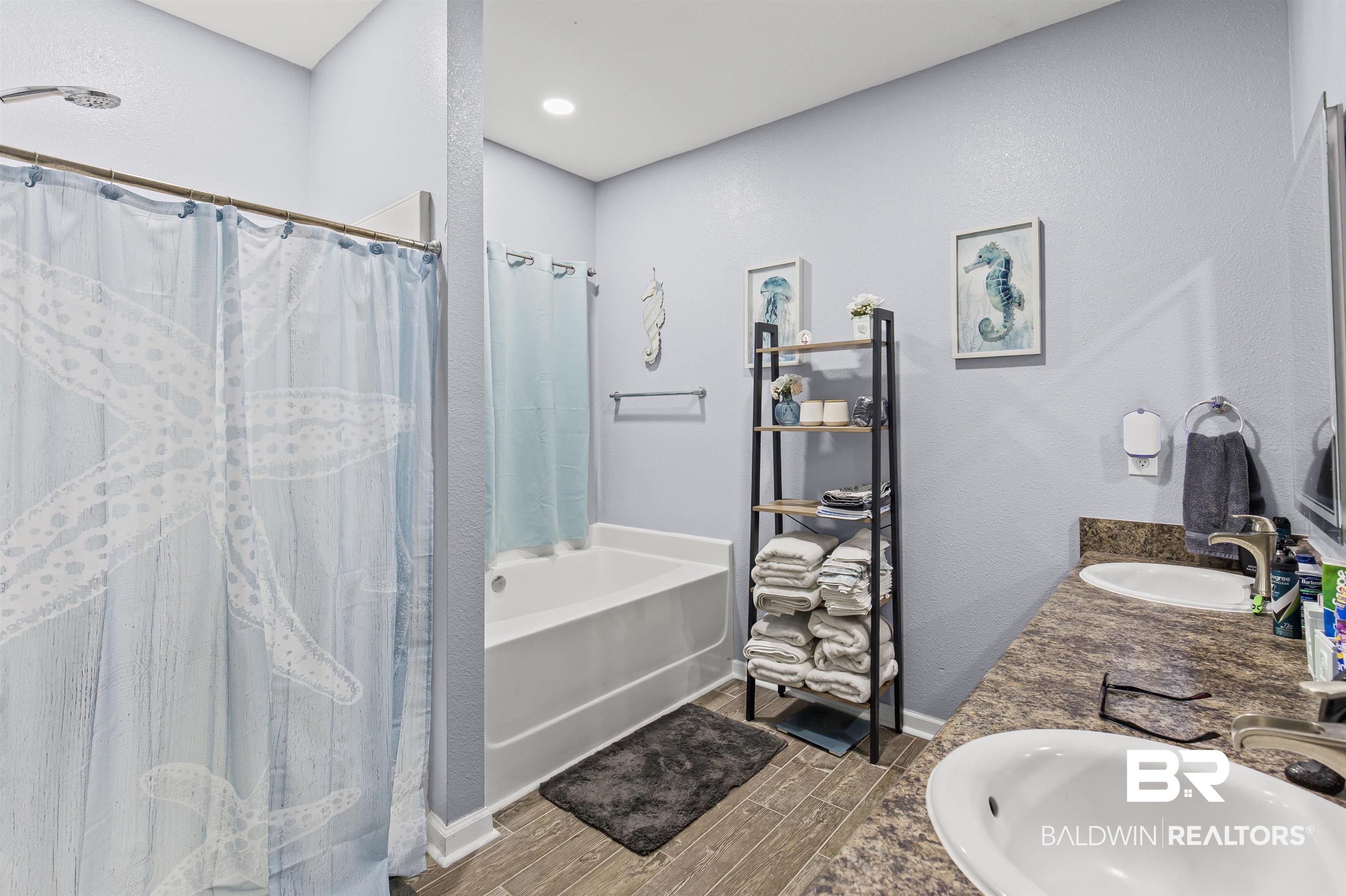 4107 Nottingham Drive Semmes, AL 36575 - Photo 11 of 23 Bathroom featuring a bath, wood tiled floors, a textured wall, double vanity, and a shower with curtain