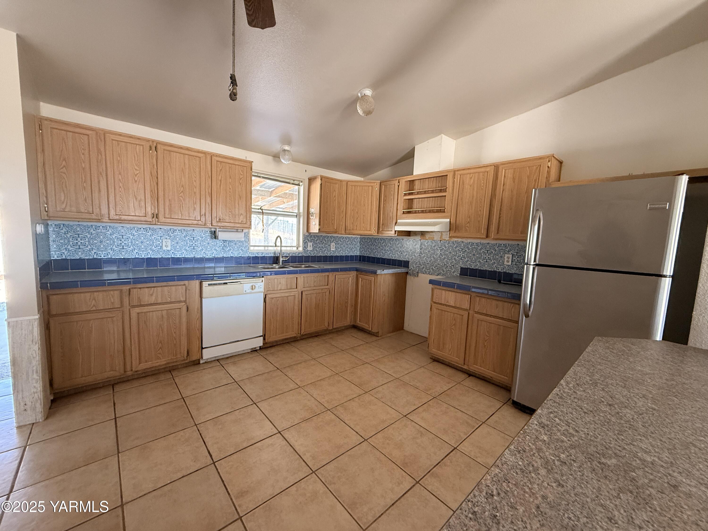 670 Hidden Valley Road Zillah, WA 98953 - Photo 8 of 17 a kitchen with stainless steel appliances granite countertop a sink and a refrigerator