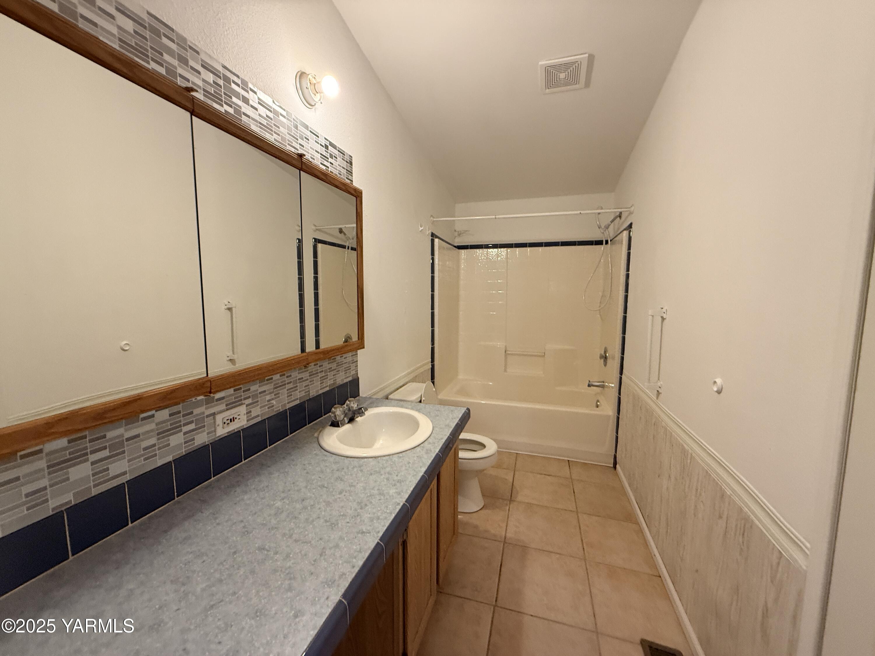 670 Hidden Valley Road Zillah, WA 98953 - Photo 10 of 17 a bathroom with a granite countertop sink a mirror and a bathtub